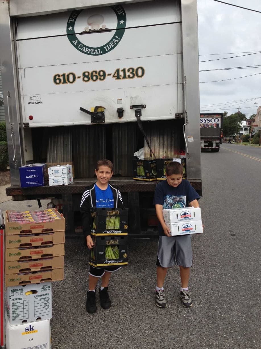Clovero founder Joe Starkey, left, and his brother at a Capital produce delivery